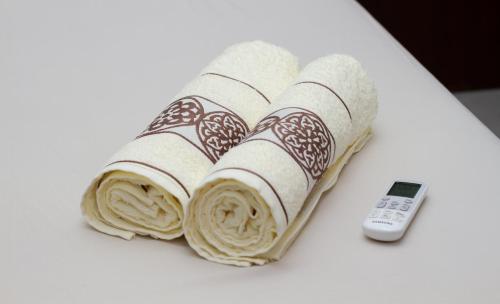 a group of rolled towels next to a remote control at Pousada Pôr Do Sol in Varginha