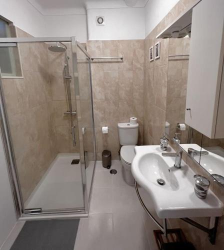 a bathroom with a shower and a sink and a toilet at Guiki House in Lisbon