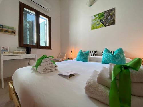 a bedroom with a white bed with blue and green pillows at Agriturismo Pranu in Sorgono