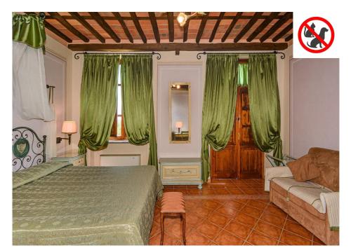 a bedroom with green curtains and a bed and a couch at Hotel Villa Cheli in Lucca