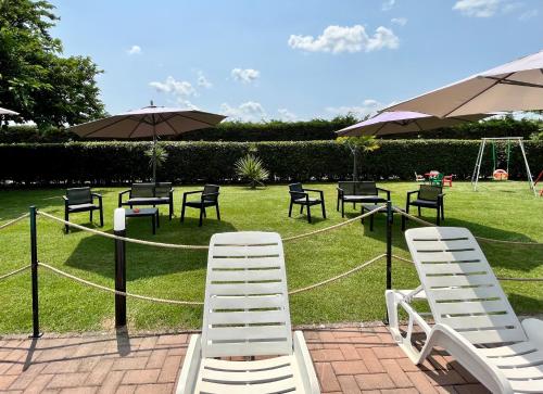 a group of chairs and tables and umbrellas on a lawn at Oasi di Agilla in Panicarola