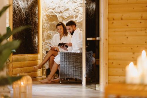 a bride and groom sitting in a chair at their wedding at Górska Legenda Apartamenty & Domki in Szczyrk