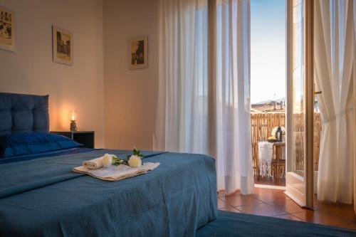 1 dormitorio con cama azul y balcón en La casa di Lucca - terrace and parking, en Lucca