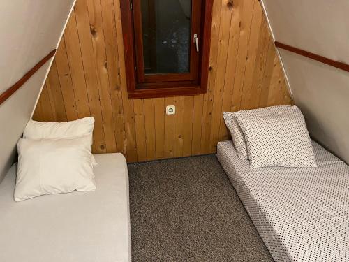 a small room with two beds and a window at Vikendica Jahorina J&K in Pale