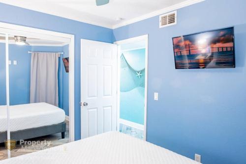 a blue bedroom with a bed and a mirror at Rays by the Bay in Tampa