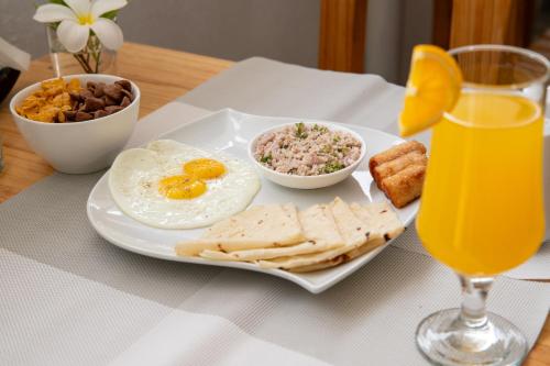 a breakfast plate with eggs and crackers and a glass of orange juice at Biosphere Inn in Dharavandhoo