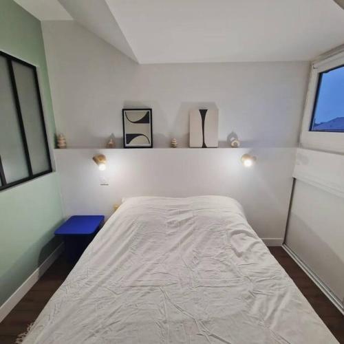 une chambre avec un grand lit blanc dans une pièce dans l'établissement Appartement Cosy Centre-Ville, à Angers