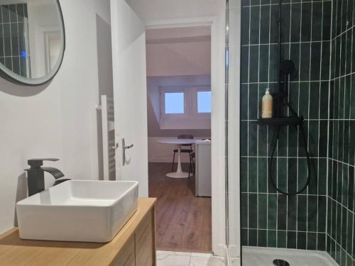 une salle de bain avec un lavabo et une douche avec un miroir dans l'établissement Appartement Cosy Centre-Ville, à Angers
