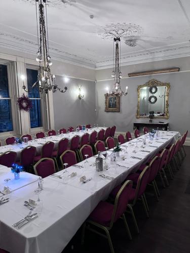 a conference room with a long table and chairs at The Old Manor House Hotel in Keynsham
