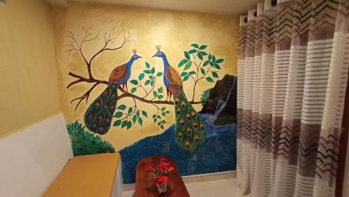 a painting of three peacocks on a wall at Nimal's House in Dickwella