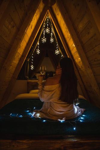 a woman sitting on a bed in a attic at Natures Escape Kozarica in Šavnik
