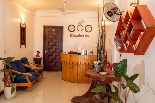 a living room with a blue chair and a table at Biosphere Inn in Dharavandhoo