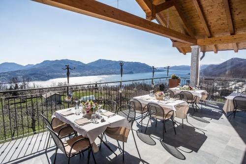 a patio with tables and chairs with mountains in the background at Residence Usignolo in Trarego