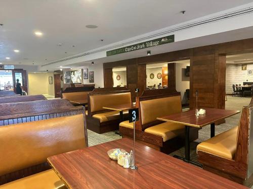 a restaurant with wooden tables and chairs and a bar at Cape Cod Irish Village - The Emerald Resort in Barnstable