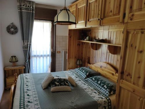 sypialnia z dużym łóżkiem i drewnianymi szafkami w obiekcie Appartamento comodo e curato per famiglie w mieście Pieve di Cadore