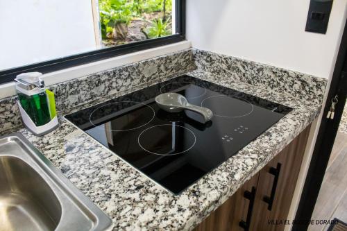 a kitchen counter with a sink and a stove at Villa El Bosque Dorado in Fortuna