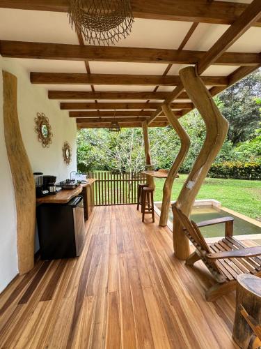 a patio with a wooden floor and a table and chairs at Passion Fruit Lodge in Cahuita