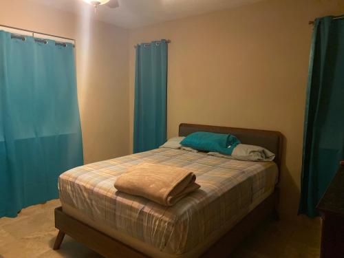 a bedroom with a bed with blue curtains at Top of the Hill Blue Sunshine in Long Swamp