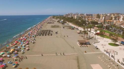 una playa con muchas sombrillas y el océano en A&C Centro-Torre del mar - Málaga, en Torre del Mar
