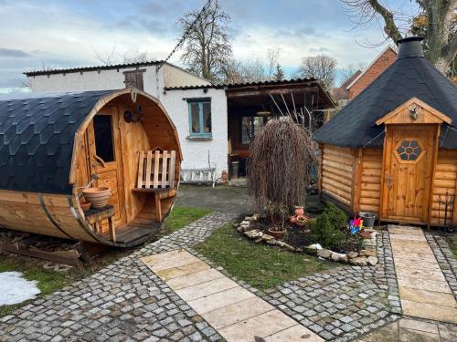 a large wooden hobbit house and a small house at Wellness Oase auf dem Land in Buttstädt