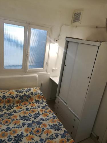 1 dormitorio pequeño con 1 cama y 2 ventanas en Hotel Ciudad Feliz en Mar del Plata