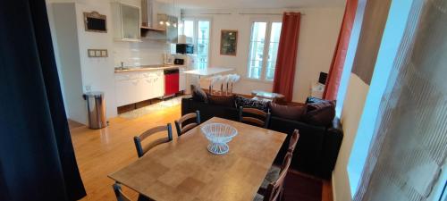 a kitchen and a dining room with a table and chairs at Double gite, Duplex et Chaleureuse petite maison in Beaumont-sur-Sarthe