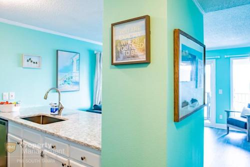 una cocina con paredes azules y una foto en la pared en VIP on the Bay en Tampa