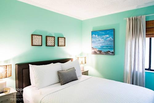 1 dormitorio con cama blanca y pared azul en VIP on the Bay en Tampa