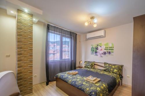 1 dormitorio con cama y ventana en Cozy & Delightful Apart & AUBG & Free Garage Parking, en Blagoevgrad