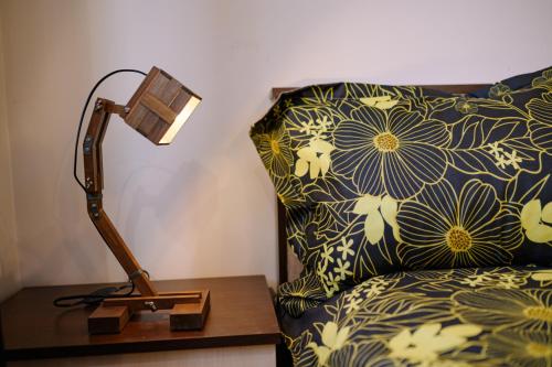 a lamp on a table next to a bed with a pillow at Cozy & Delightful Apart & AUBG & Free Garage Parking in Blagoevgrad