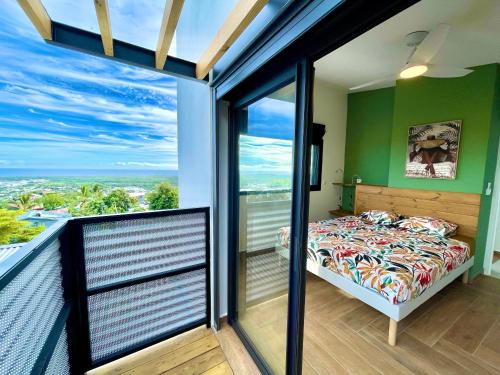 - une chambre avec un lit et un balcon avec vue dans l'établissement Vacoa - Villa Salba. Panoramic view., à L'Étang-Salé