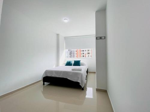 1 dormitorio con 1 cama en una habitación blanca en Excepcional Apartamento -WAIWA HOST, en Bucaramanga