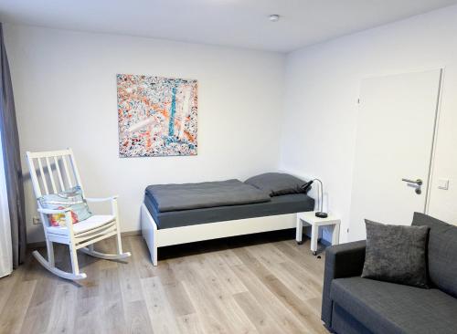 ein Schlafzimmer mit einem Bett, einem Stuhl und einem Sofa in der Unterkunft Ferienwohnung Lippstadt in Lippstadt