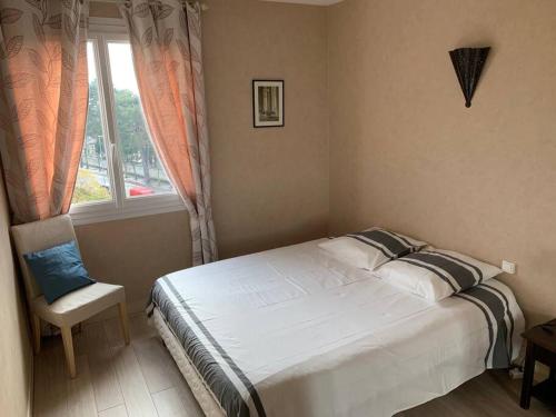 une chambre avec un lit, une fenêtre et une chaise dans l'établissement Appartement de charme, 76 m2, Quartier St GABRIEL, à Caen