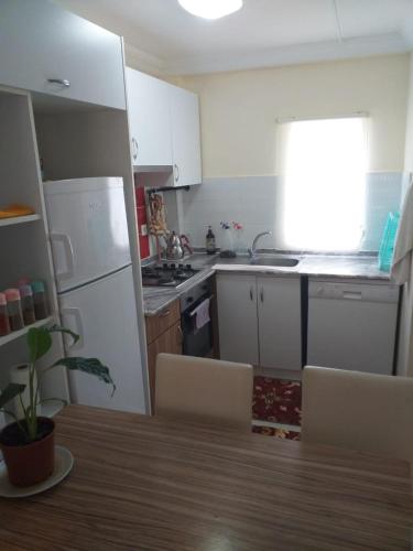 a kitchen with a white refrigerator and a table with chairs at Emet Resort Apart Otel in Emet