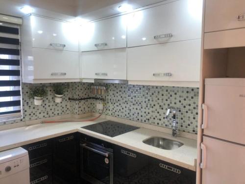 a small kitchen with white cabinets and a sink at Emet Resort Apart Otel in Emet