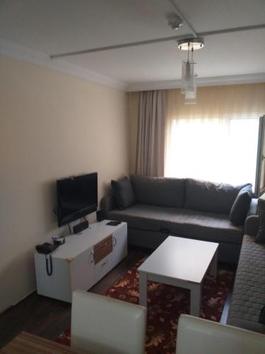 a living room with a couch and a tv at Emet Resort Apart Otel in Emet