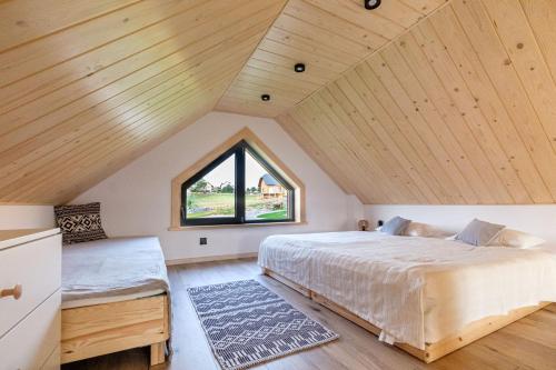 Un dormitorio con una cama grande y una ventana en Olecka Village, en Jaworzynka
