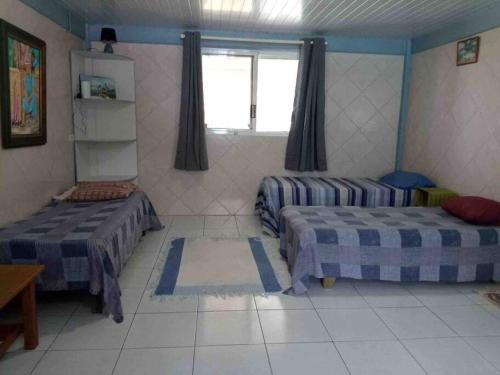 a room with two beds and a window at Meri Lodge Huahine (Mamado’s House) in Fare