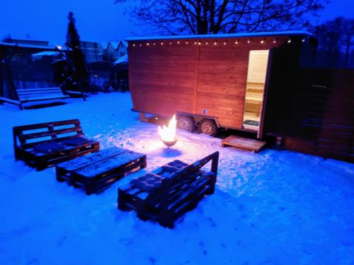 a fire pit in the snow in front of a cabin at Chill House in Mrągowo