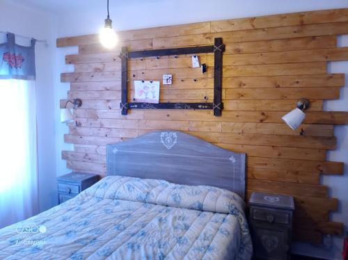 a bedroom with a wooden wall with a bed at Alloggio turistico Fiocco di Neve Cod reg 27059 in Filettino