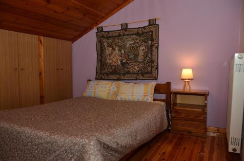 1 dormitorio con 1 cama y tapiz en la pared en Σοφίτα, en Graviá