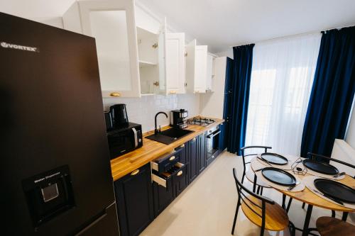 uma cozinha com armários pretos e uma mesa com cadeiras em Modern Loft em Suceava