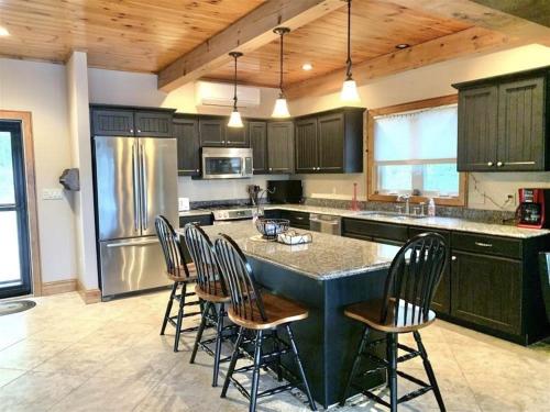 a kitchen with a large island with chairs around it at OWL HOUSE LIMIT 8 home in Wakefield