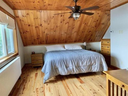 a bedroom with a bed with a wooden ceiling at OWL HOUSE LIMIT 8 home in Wakefield