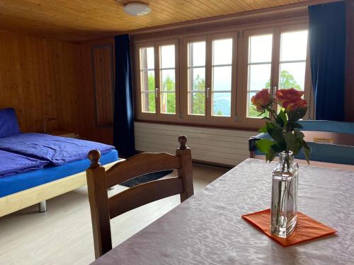 Una habitación con una mesa con un jarrón de flores. en Birchihaus, en Beatenberg