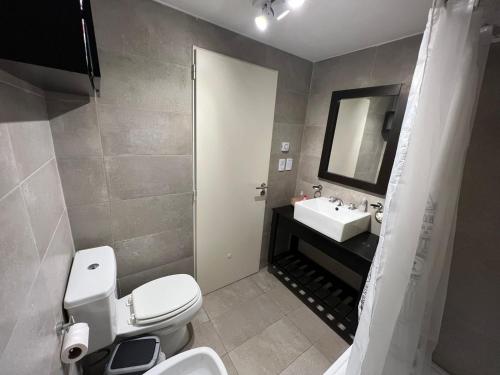 uma casa de banho com um WC branco e um lavatório. em Confortable departamento en Castelar - Zona Céntrica. em Castelar