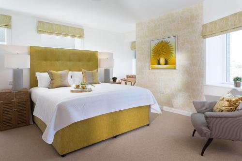 a bedroom with a large bed and a chair at Scots Craig in St Ives