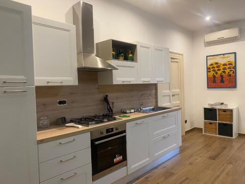 a kitchen with white cabinets and a stove top oven at Via Rivocati 108 in Cosenza