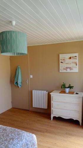 - une chambre avec un lit, une commode et un plafond dans l'établissement La cousinade No, à Noirmoutier-en-l'lle